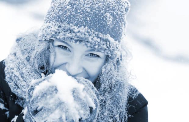 Femme dans la neige, emmitouflée pour se protéger du syndrome de Raynaud